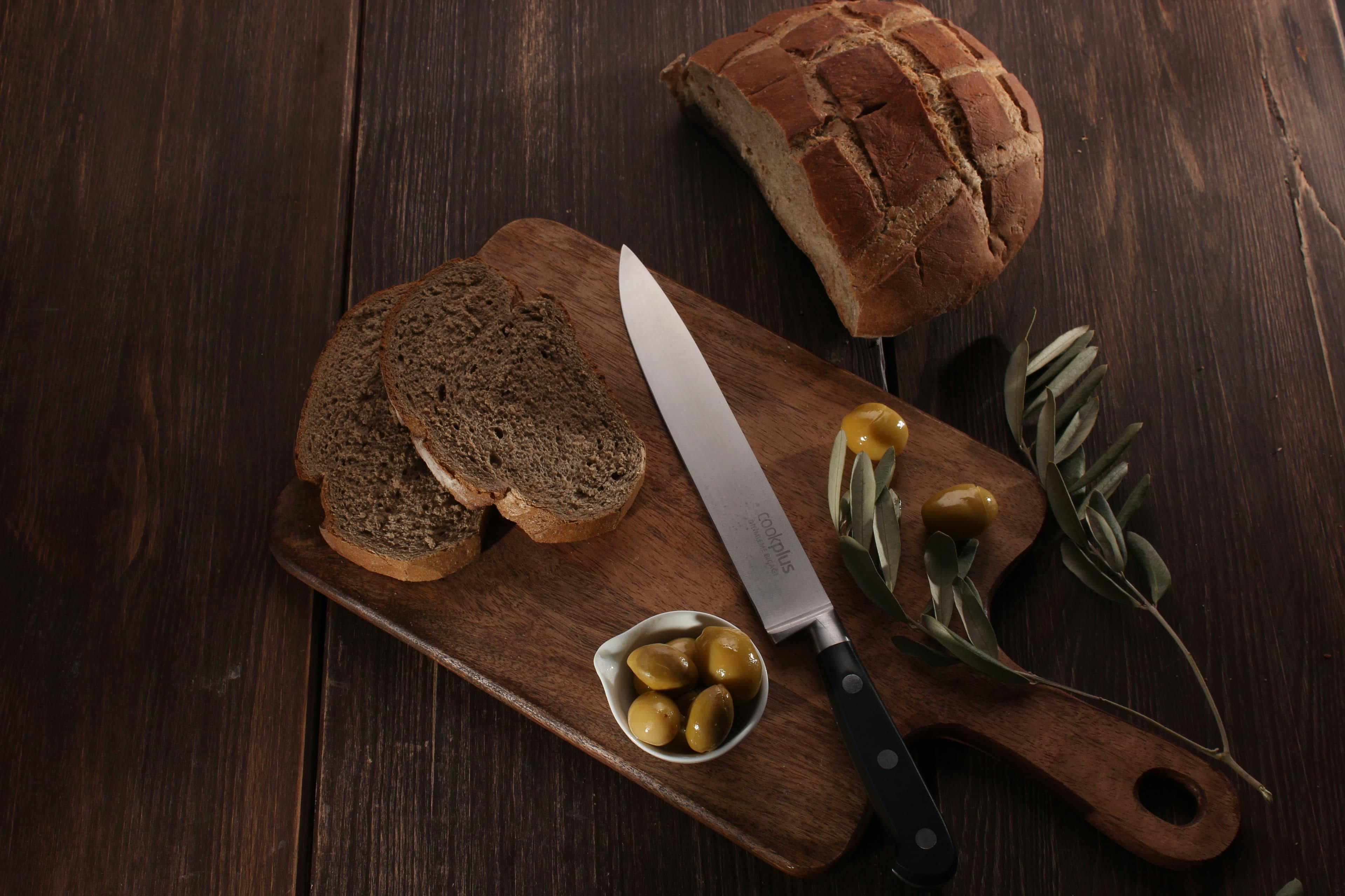 A crusty loaf of bread sliced on a wooden board.
